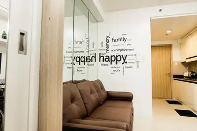 a living room with a couch and words on the wall at Family Suite near MOA in Manila