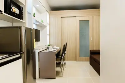 a kitchen with a table and chairs in a room at Family Suite near MOA in Manila