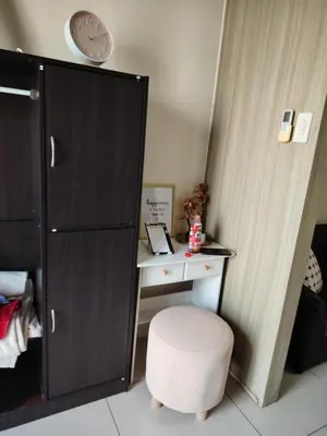 a desk with a white stool next to a cabinet at Affordable Breeze Residence unit 2118 in Manila