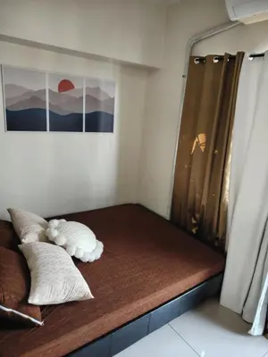 a bed with two pillows on it in a room at Affordable Breeze Residence unit 2118 in Manila