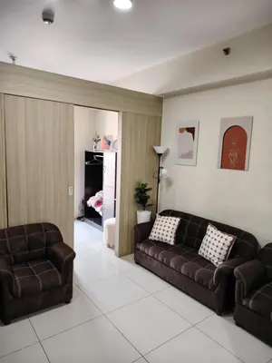 a living room with two brown leather couches at Affordable Breeze Residence unit 2118 in Manila