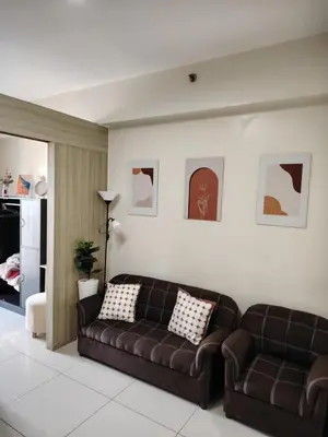 a living room with two brown couches in a room at Affordable Breeze Residence unit 2118 in Manila
