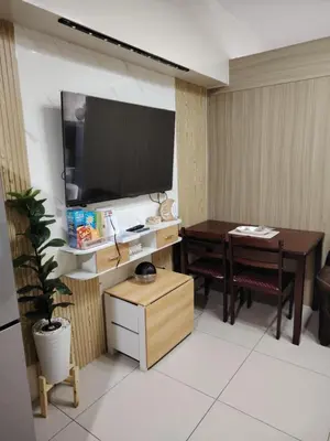 a living room with a table and a television at Affordable Breeze Residence unit 2118 in Manila