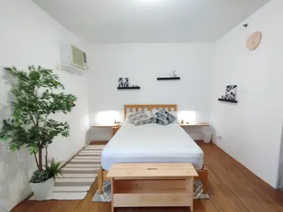 a bedroom with a bed and a potted plant at Delet TEA in Manila