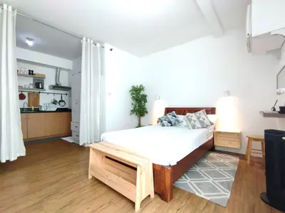 a bedroom with a bed and a kitchen at Delet TEA in Manila