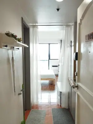 a hallway with a door to a room with a bed at Delet CITADEL in Manila