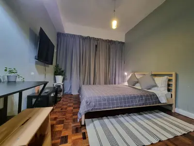 a bedroom with a bed and a table and a television at Delet CITADEL in Manila