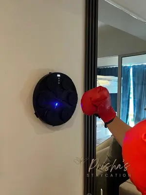 a person wearing boxing gloves pointing at a mirror at Prisha Staycation in Manila
