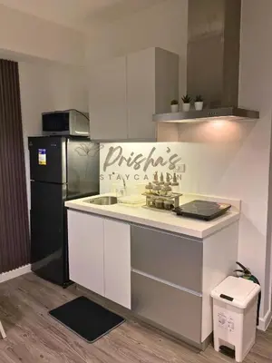 a kitchen with a white counter and a refrigerator at Prisha Staycation in Manila