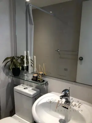 a bathroom with a sink and a toilet and a mirror at Prisha Staycation in Manila