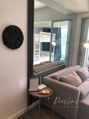 a living room with a couch and a mirror at Prisha Staycation in Manila