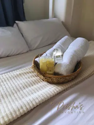 a basket of towels and drinks on a bed at Prisha Staycation in Manila