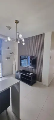 a living room with a table and a tv at Rikki Staycation in Manila