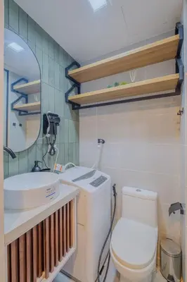 a bathroom with a toilet and a sink and a mirror at Coasis at SMDC Coast Residences in Manila