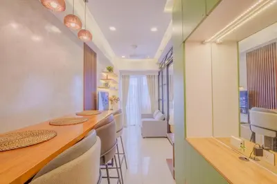 a dining room with a long table and chairs at Coasis at SMDC Coast Residences in Manila