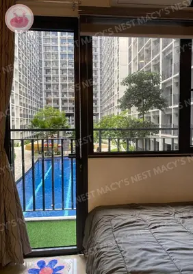 a bedroom with a view of a swimming pool through a window at Shore 2 Tower 1 - Macy's Nest - Near MOA in Manila