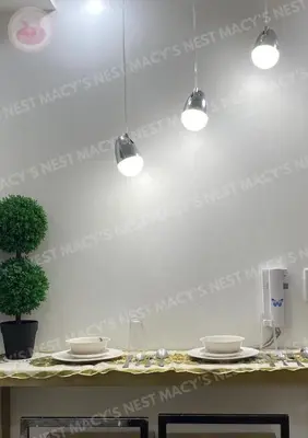 a table with plates and glasses and lights on the wall at Shore 2 Tower 1 - Macy's Nest - Near MOA in Manila