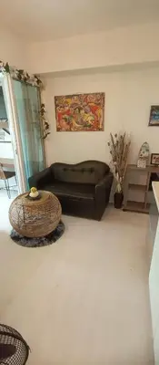 a living room with a black couch and a table at Casa Crisav Staycation place at AZURE in Manila