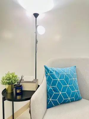 a blue pillow sitting on a table next to a couch at Micasa at Green 2 Residences in Dasmariñas