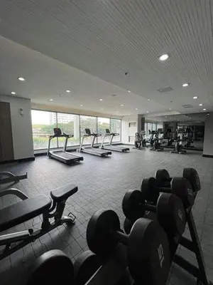 a gym with rows of dumbbells in a room at Micasa at Green 2 Residences in Dasmariñas