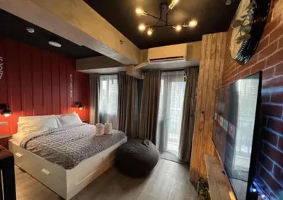 a bedroom with a bed in a room with red walls at Executive Suite 710A at S Residence by GK Condotel in Manila