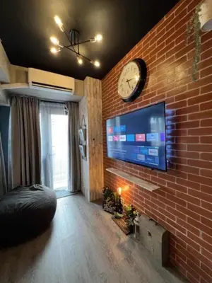 a room with a brick wall with a clock on the wall at Executive Suite 710A at S Residence by GK Condotel in Manila