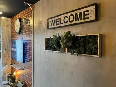 a welcome sign on a wall with plants at Executive Suite 710A at S Residence by GK Condotel in Manila