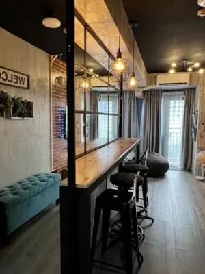 a room with a bar with stools and a couch at Executive Suite 710A at S Residence by GK Condotel in Manila