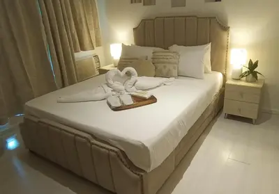 a bedroom with a bed with two swans on it at Casa Crisav Staycation place at AZURE in Manila