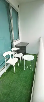 a group of white chairs and a table in a room at Casa Crisav Staycation place at AZURE in Manila