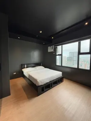 a bedroom with a bed and a large window at Malate Bayview Mansion 37M in Manila