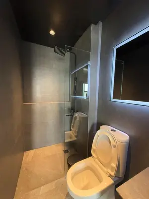 a bathroom with a toilet and a shower at Malate Bayview Mansion 37M in Manila
