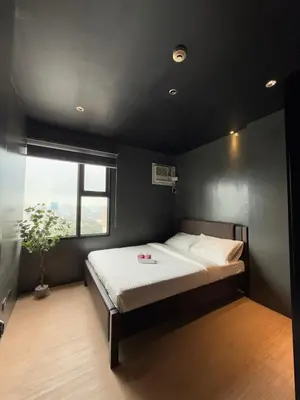 a bedroom with a bed in a room with a window at Malate Bayview Mansion 37M in Manila