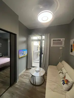 a living room with a white couch and a table at Gentry Manor 2-Bed Near MOA&NAIA Okada Seaviw TV Netflix 17U in Manila