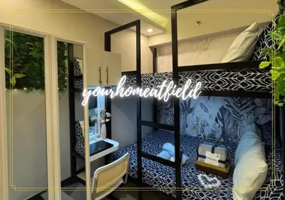 a room with a bunk bed with a mirror at Your HOME At Field Residences in Manila