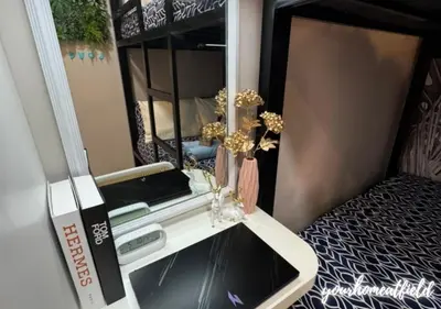 a room with a mirror and a table with flowers at Your HOME At Field Residences in Manila
