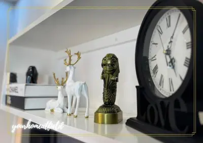 a clock sitting on a shelf next to a statue at Your HOME At Field Residences in Manila