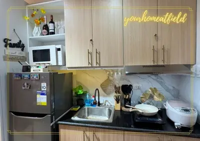 a kitchen with a sink and a refrigerator at Your HOME At Field Residences in Manila