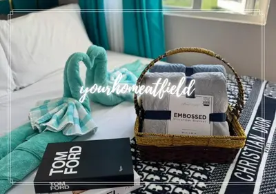 a basket of towels and a laptop on a bed at Your HOME At Field Residences in Manila