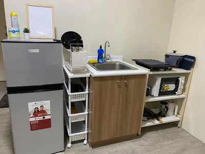 a kitchen with a sink and a refrigerator at The Mood Shift in Manila