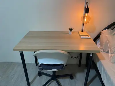 a desk with a lamp and a chair next to a bed at The Mood Shift in Manila