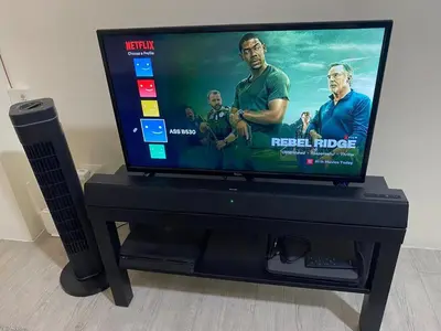 a flat screen tv sitting on top of a black stand at The Mood Shift in Manila