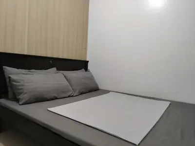 a bed with a white sheet on top of it at Shore Residences - 2 Bedroom Pool View Near Moa in Manila
