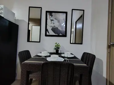 a dining room table with chairs and mirrors at Shore Residences - 2 Bedroom Pool View Near Moa in Manila