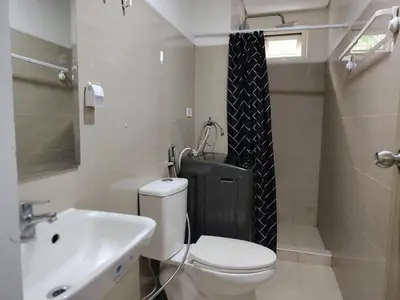 a bathroom with a white toilet and a sink at Shore Residences - 2 Bedroom Pool View Near Moa in Manila