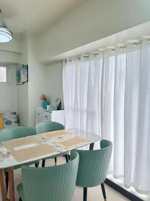 a dining room with a table and chairs and curtains at Brixton place 2815 Weston tower in Manila