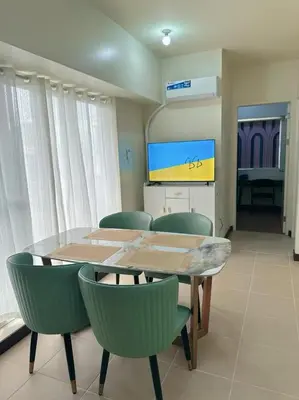 a dining room with a table and green chairs at Brixton place 2815 Weston tower in Manila
