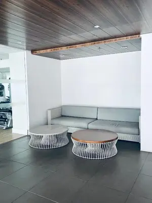 a living room with a couch and two tables at Crisean Highrise Condo - 100 West makati in Manila