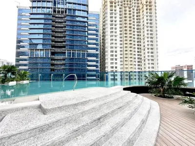 a large fountain in a city with tall buildings at Crisean Highrise Condo - 100 West makati in Manila