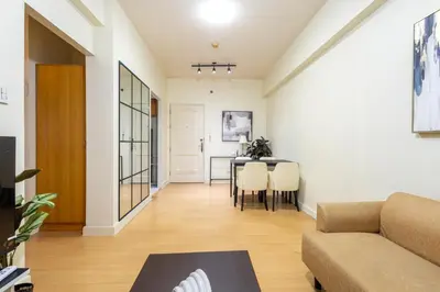a living room with a couch and a table at Forbeswood Heights 1Br with Garden view in Manila